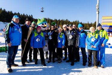 Helferinnen und Helfer mit dem Maskottchen "Flocke"